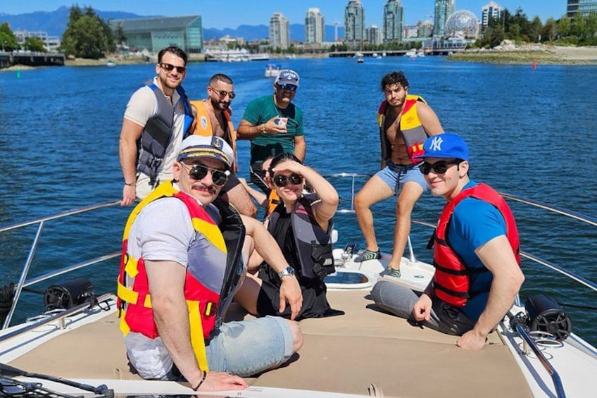 Un grupo de personas en un bote con chalecos salvavidas, con un horizonte urbano de fondo. 5