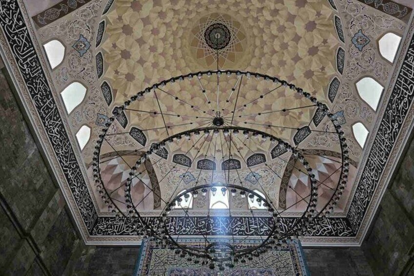 A ceiling with intricate geometric patterns and a central circular design. 4