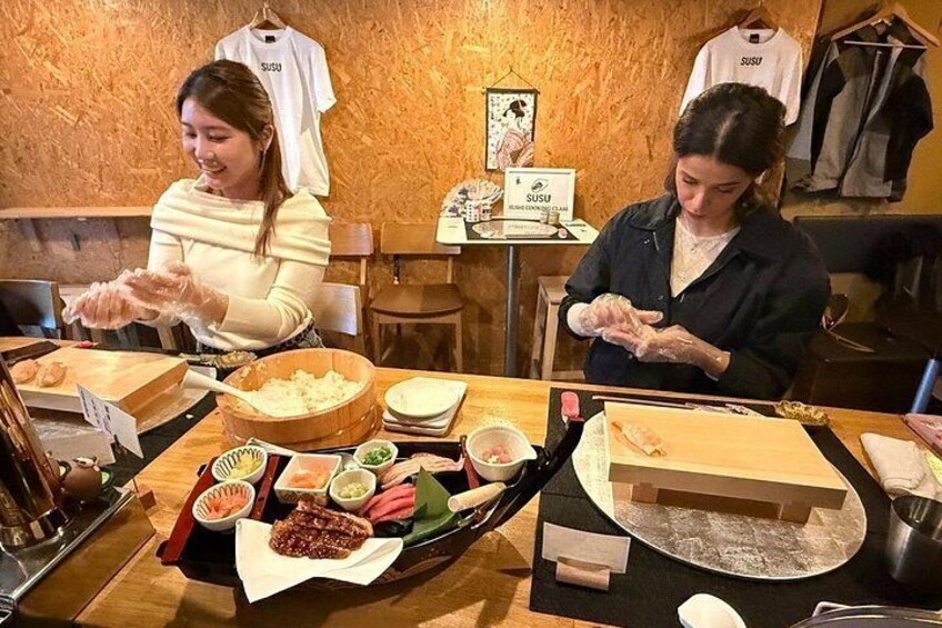 Two people preparing sushi at a restaurant. 2