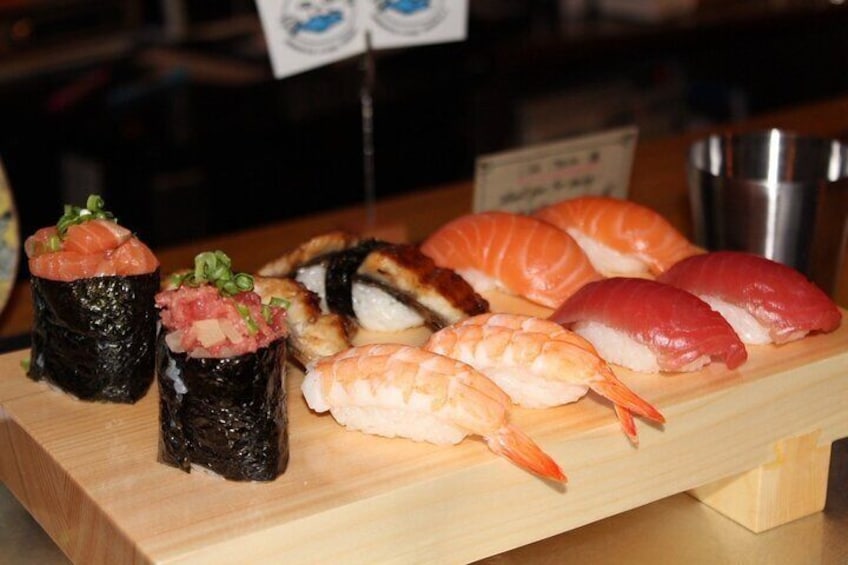 A variety of sushi on a wooden board, including nigiri and sashimi. 1