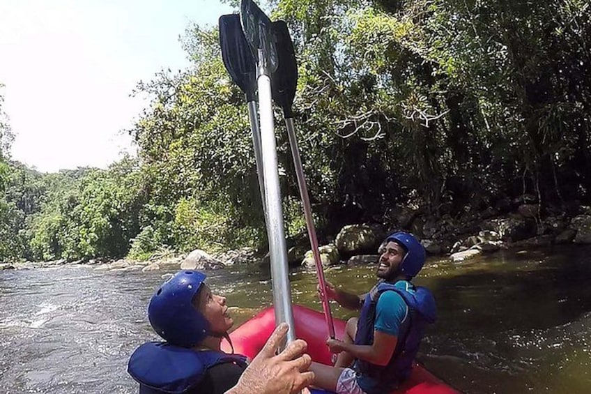 Two people in a red raft on a river, holding paddles. 3