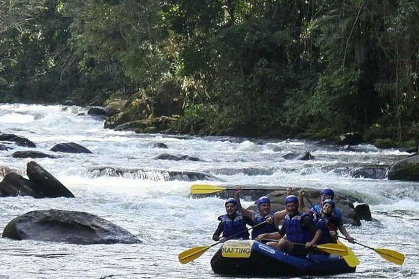 A group of people rafting down a river with rapids, surrounded by rocks and greenery. 2