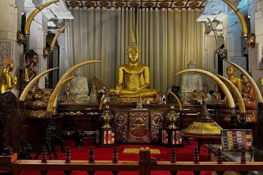 A golden Buddha statue in a temple with ornate decorations and a red carpet. 4