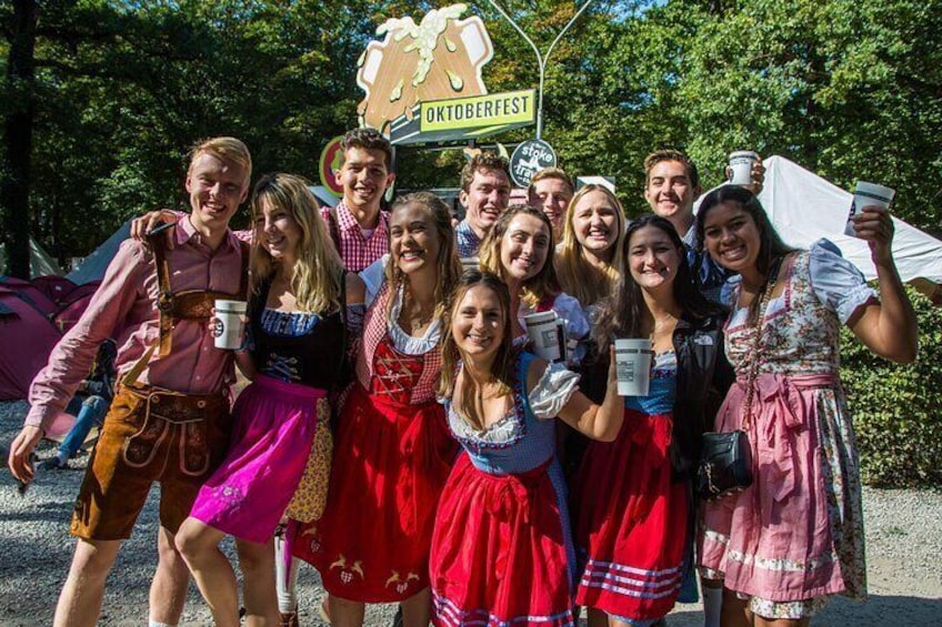 Eine Gruppe von Menschen in traditioneller bayerischer Tracht posiert für ein Foto auf dem Oktoberfest. 1