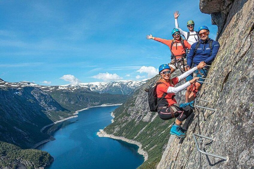 A group of climbers on a steep mountain ridge with a fjord below. 3