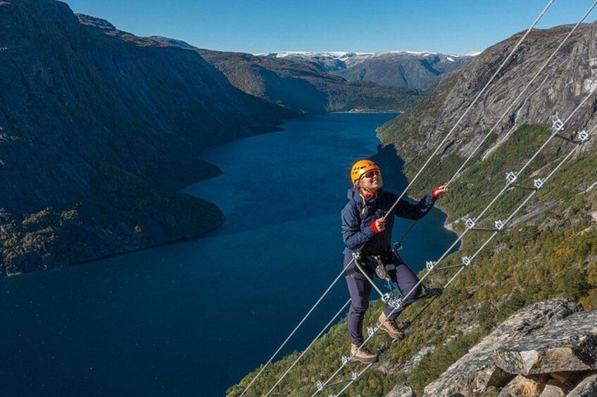 A person rappelling down a mountain with a lake in the background. 2