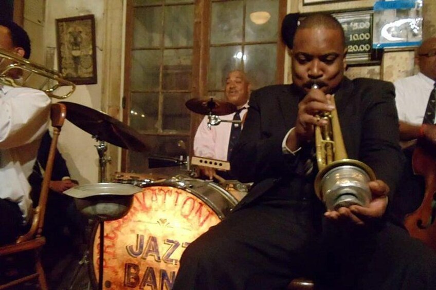 A person playing a brass instrument, a drum set, and a brass instrument with a label. 3