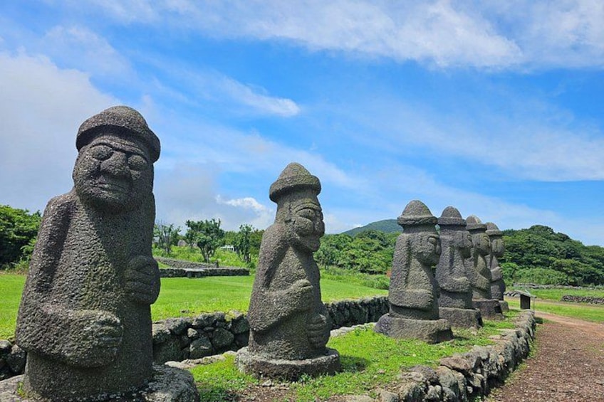 Stone statues in a grassy area with a clear sky. 5
