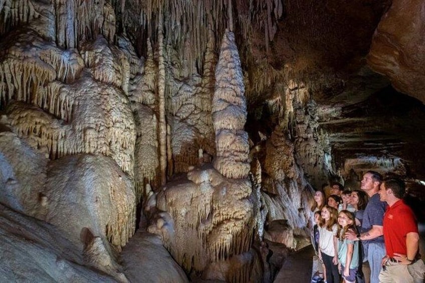A group of people inside a cave with stalactites and stalagmites. 4