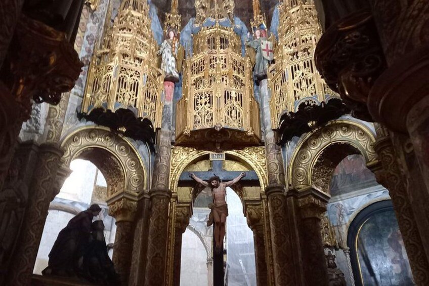 An ornate church interior with a crucifixion scene, golden decorations, and detailed architecture. 5