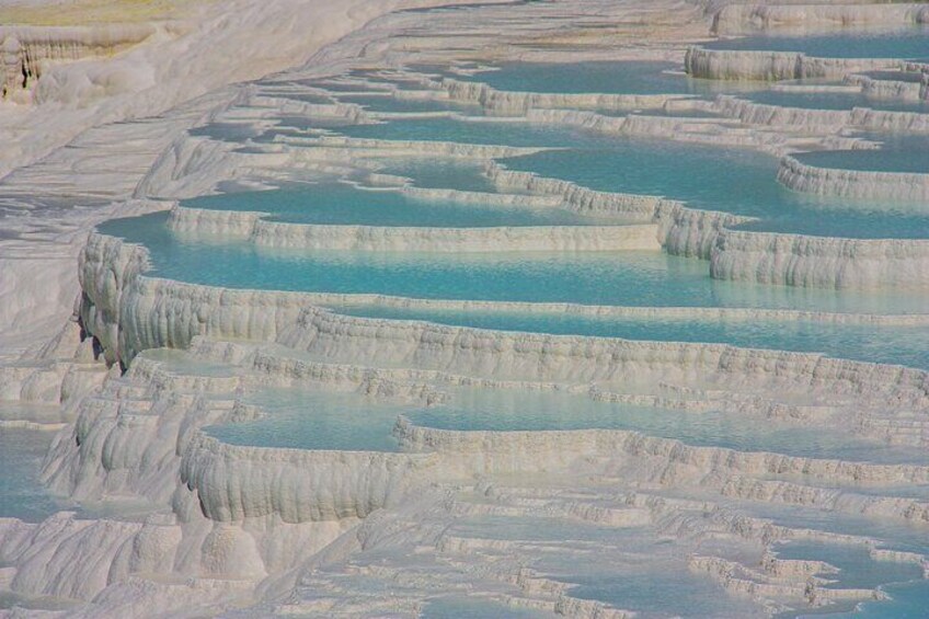 Terraced travertine formations with turquoise pools. 1