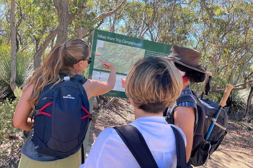 Two people examining a hiking map at a trailhead. 3