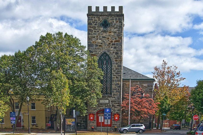 A stone church with a tall tower and a large arched window. 3