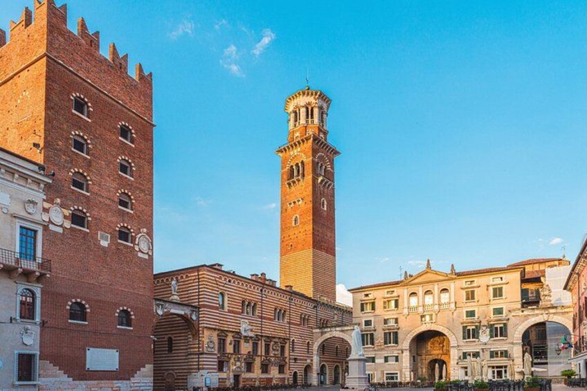 A historic square with a prominent clock tower, a red brick building, and a classical building with arches. 3