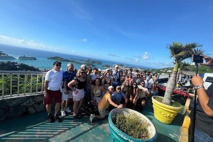 A group of people on a boat with a view of the ocean and islands. 3