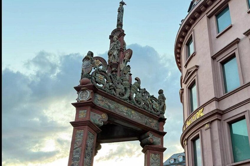 A building with ornate architectural details and a statue on top. 4