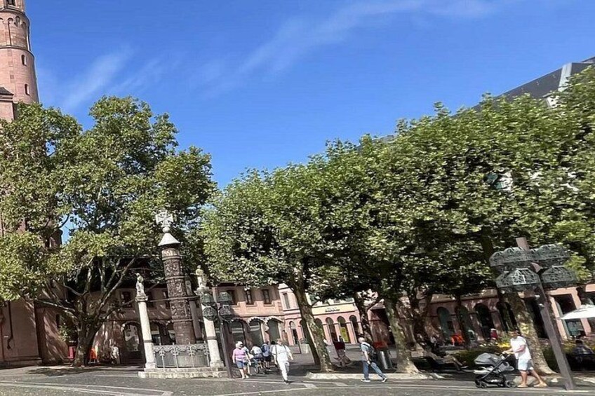 A historic building with a clock tower, surrounded by trees and a pedestrian crossing. 3