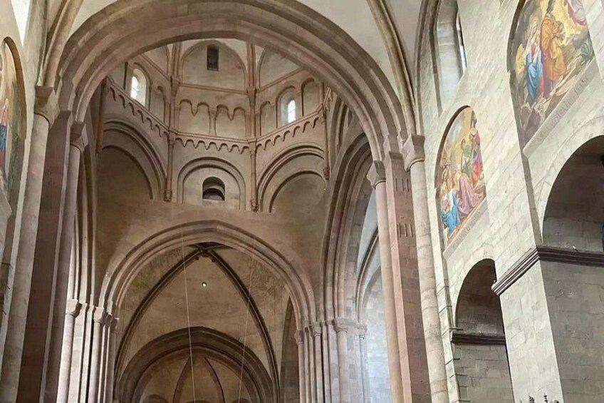 A cathedral interior with arched ceilings and stained glass windows. 5