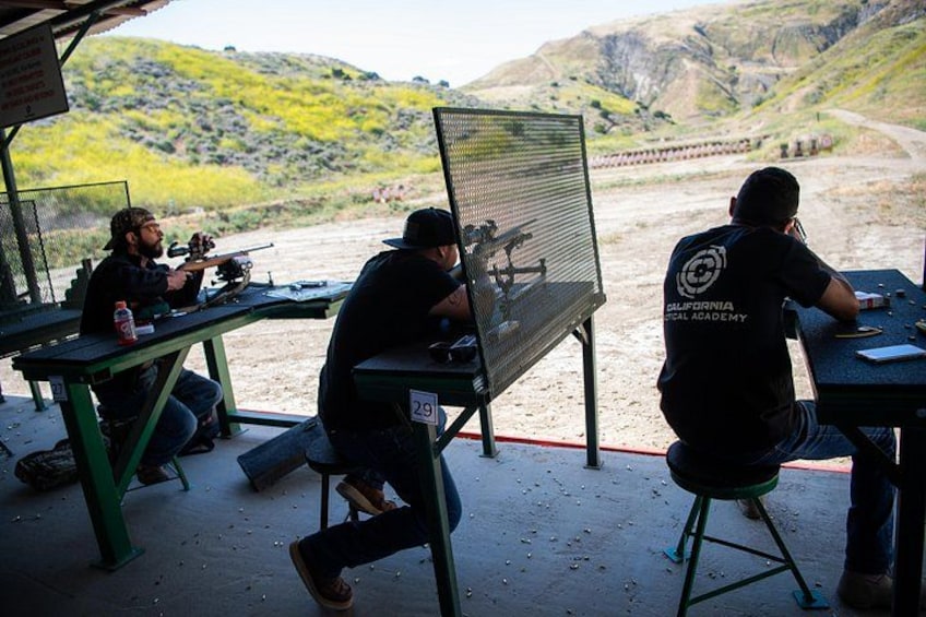 People at an outdoor shooting range with targets. 1