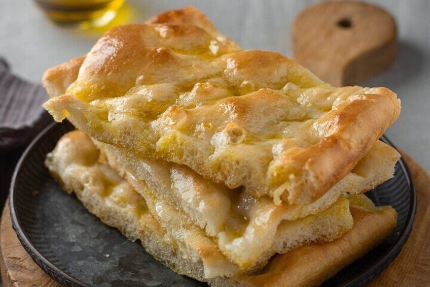 A stack of flatbread with melted cheese on a dark plate. 4