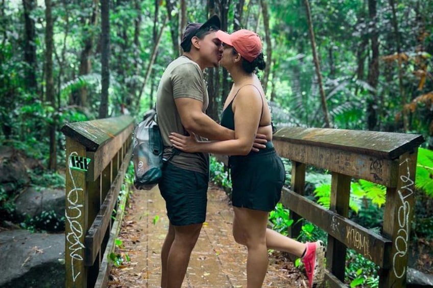 A couple embracing on a wooden bridge in a forested area. 3