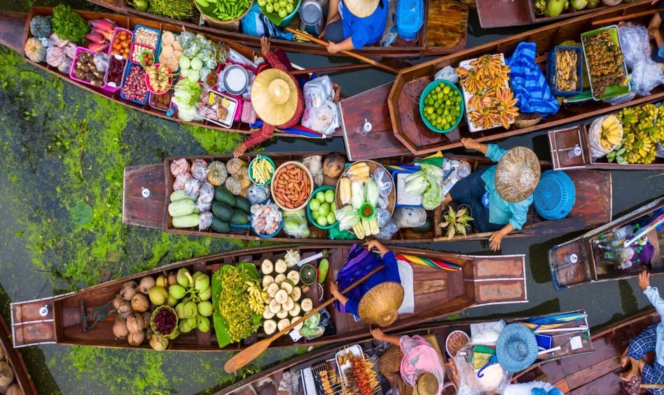 A group of canoes loaded with various fruits and vegetables. 1