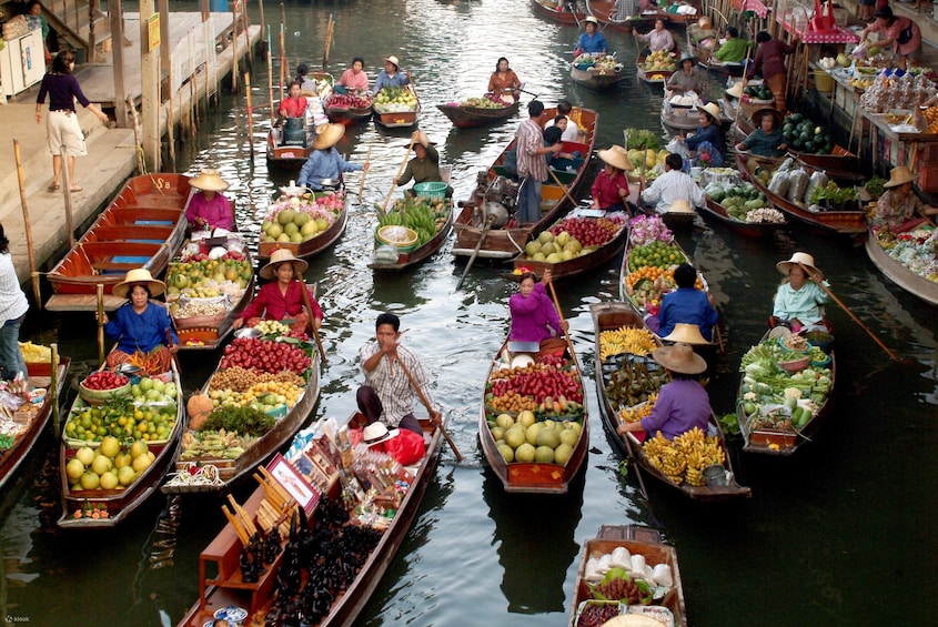 A bustling waterway with numerous boats laden with fresh produce, indicating a vibrant local market scene. 2