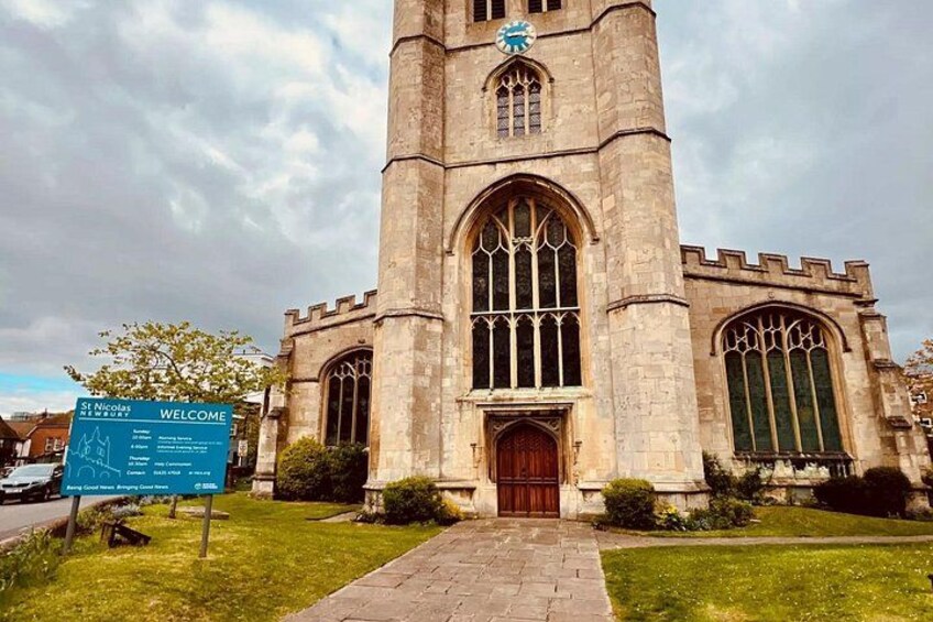 A historic church with a tall tower, large arched windows, and a welcoming sign. 4