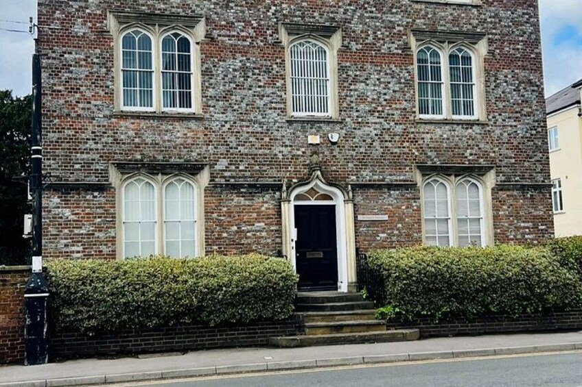 A brick building with arched windows and a central entrance. 5
