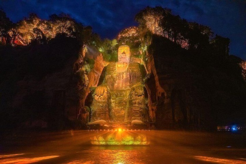 A large illuminated statue in a natural setting at night. 4