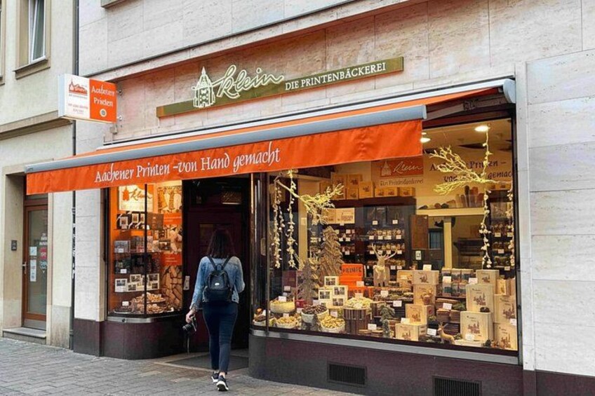 A storefront with a sign reading 'Klein - Die Printenbäckerei' and a display of baked goods. 5