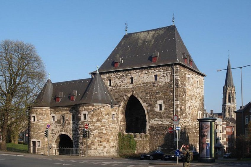 A historic stone building with multiple towers and a large arched entrance. 3