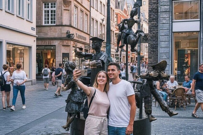 A couple taking a selfie with a statue of a knight in armor. 4