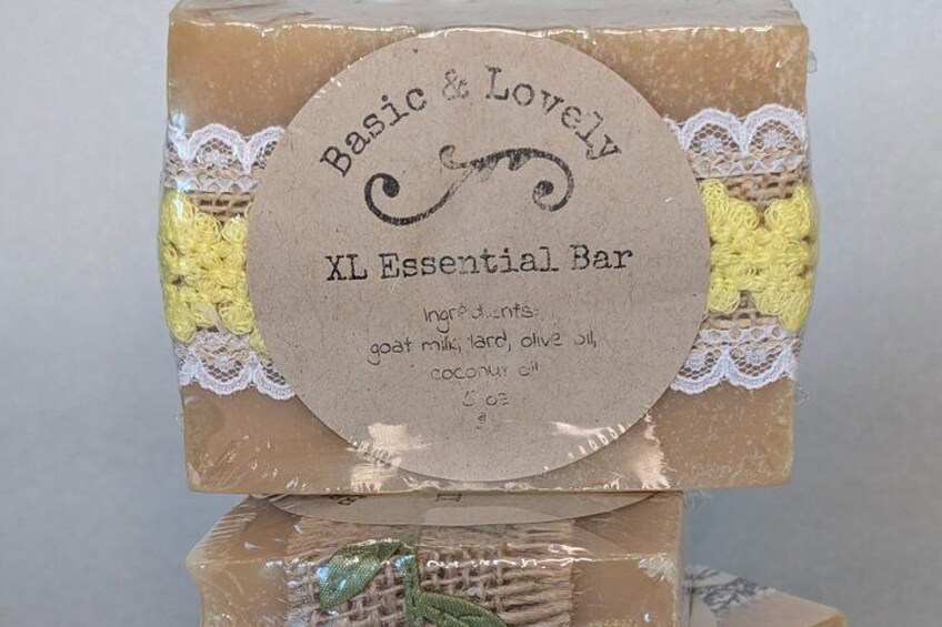 A bar of soap with a label that reads 'Basic & Lovely XL Essential Bar' and lists ingredients like goat milk, hard olive oil, and coconut oil. 4