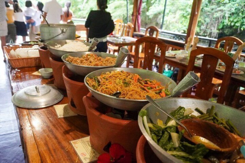 A buffet table with various dishes, including rice, noodles, and vegetables. 5