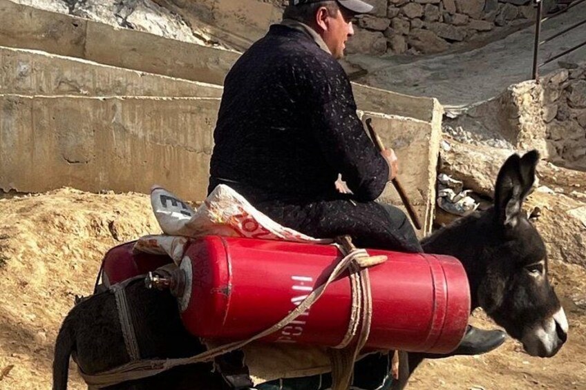 Une personne chevauchant un âne portant un baril rouge sur son dos. 4