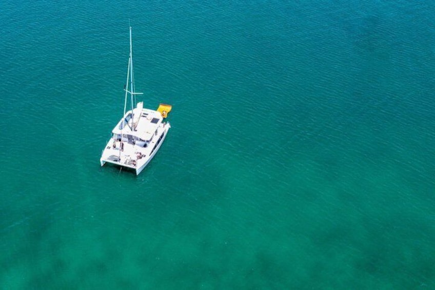 A white yacht anchored in clear turquoise waters. 4