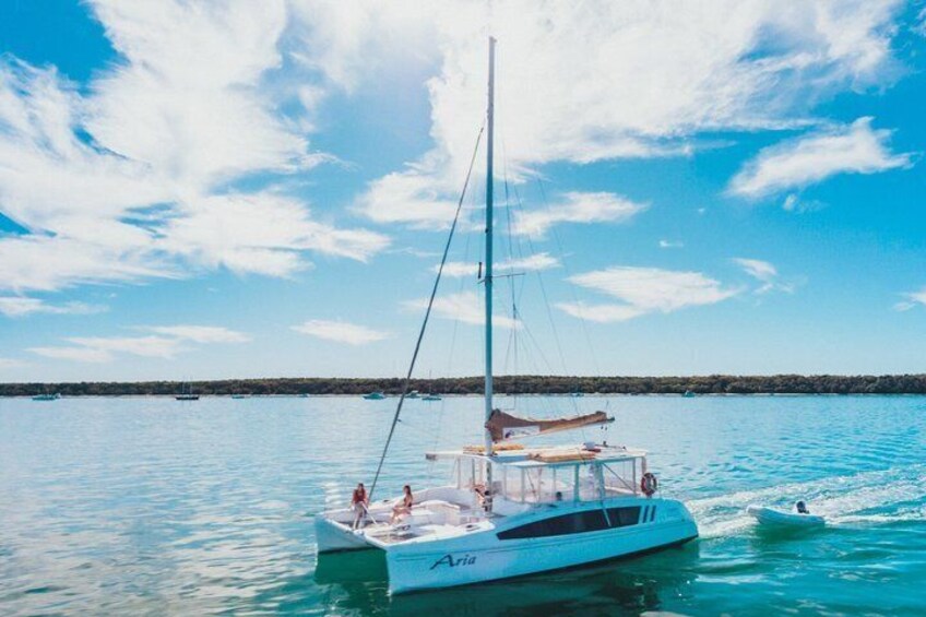 A sailboat named 'Ariat' on calm waters with a clear sky. 3