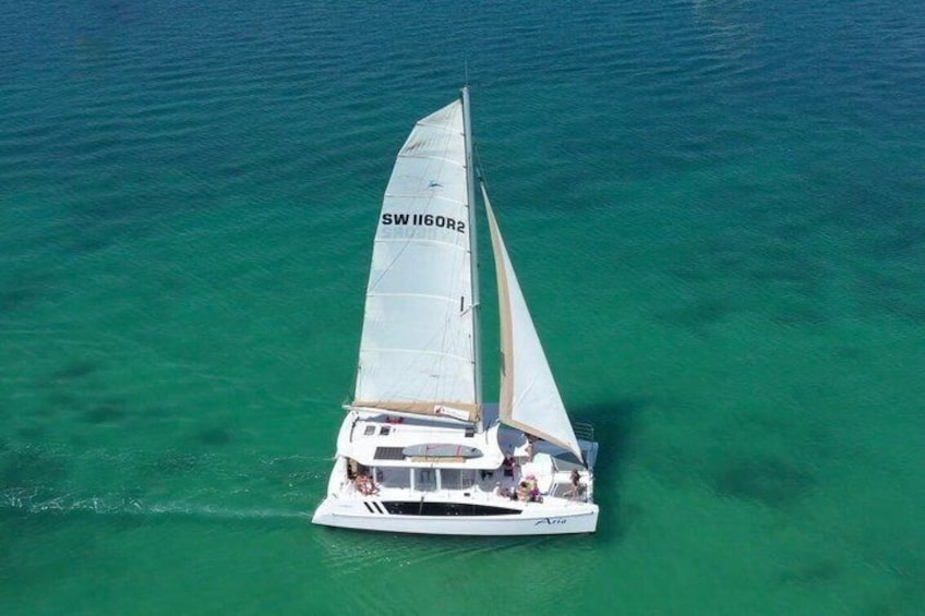 A sailboat with the registration SW1160RA sailing on turquoise waters. 2