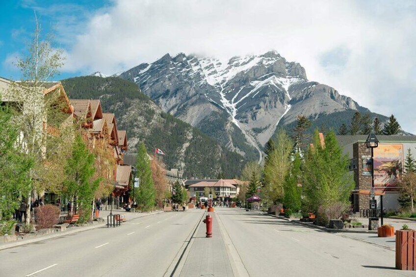 Une rue d’une ville de montagne, avec des bâtiments et une montagne enneigée en arrière-plan. 4
