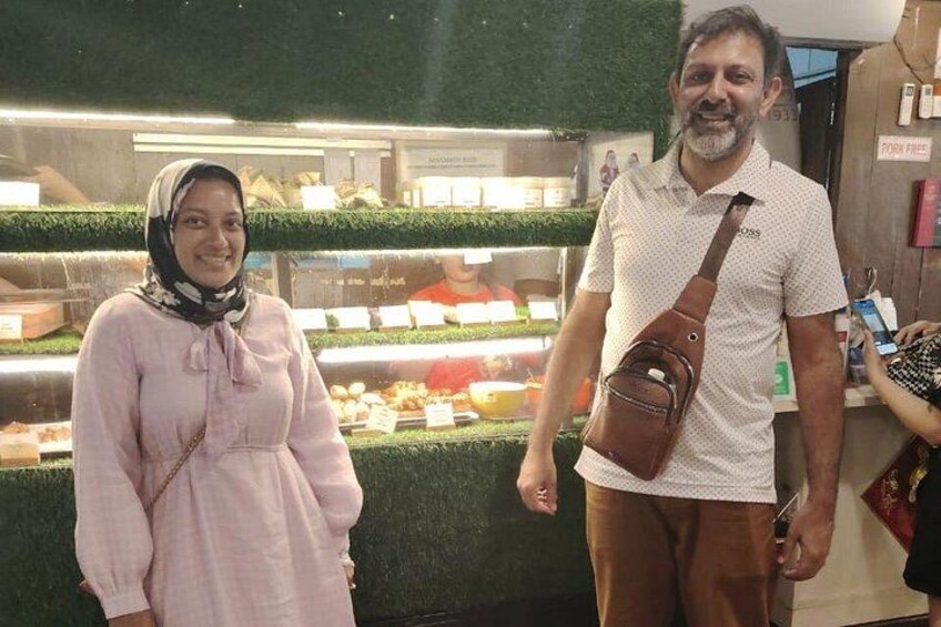 Due persone davanti a un espositore di cibo con un cartello che dice 'Pork Free'. 5
