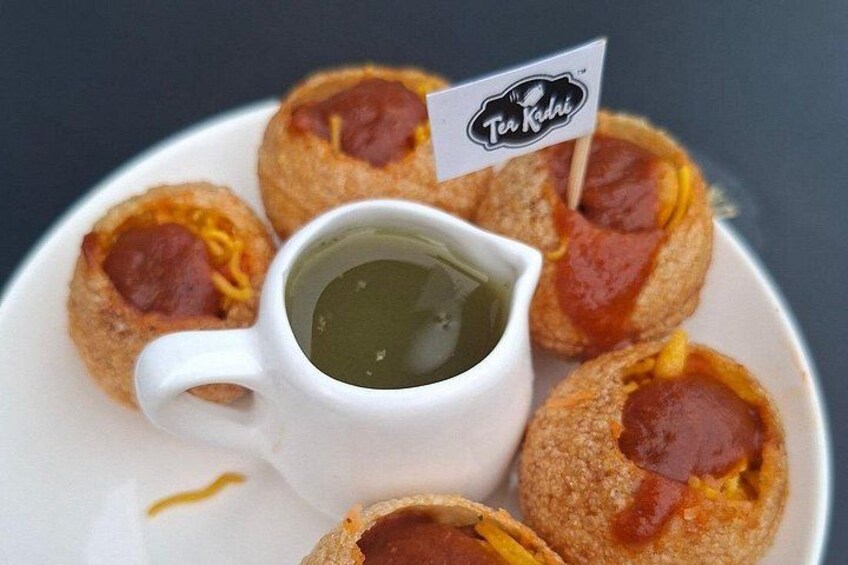 Un piatto di cibo con una piccola bandiera, una tazza di salsa e un logo. 4