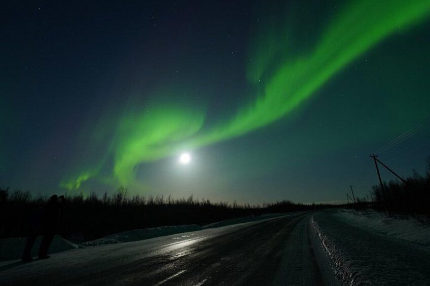 A road at night with the aurora borealis in the sky. 5
