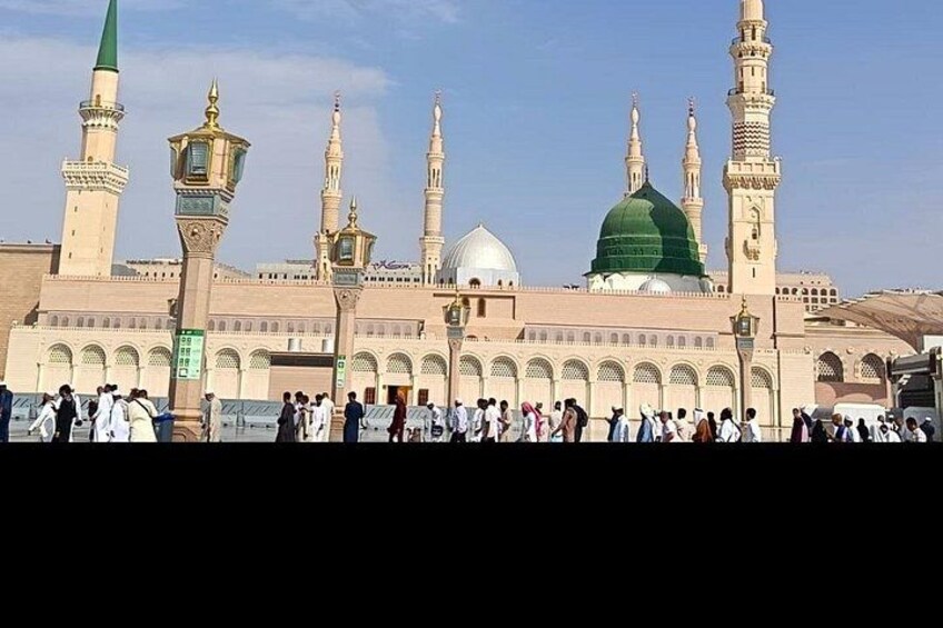 A large mosque with multiple minarets and a green dome. 3