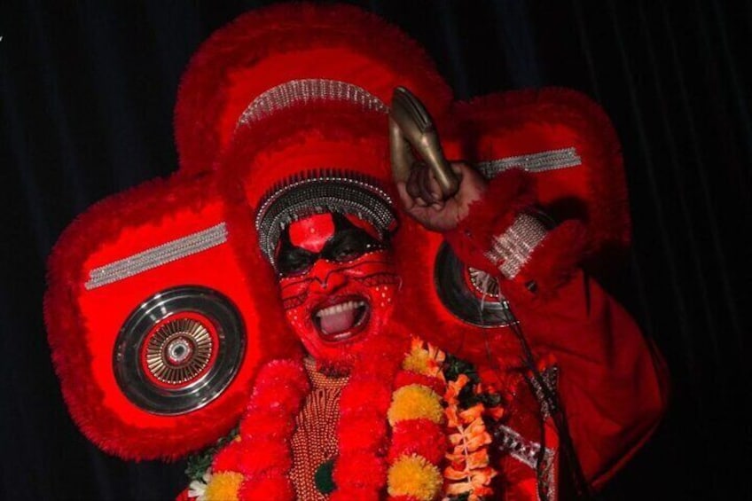 A person in a red costume with a large prop resembling a red flower. 1