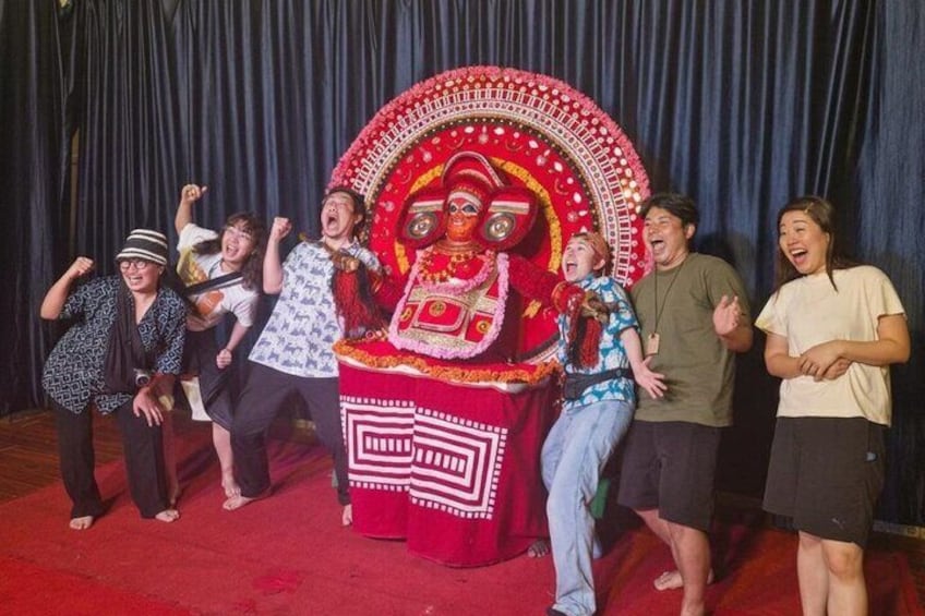 A group of people posing in front of a decorated stage with a large circular emblem. 3