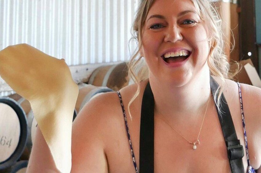 A person wearing a black top with a necklace and a strap across the shoulder. 1