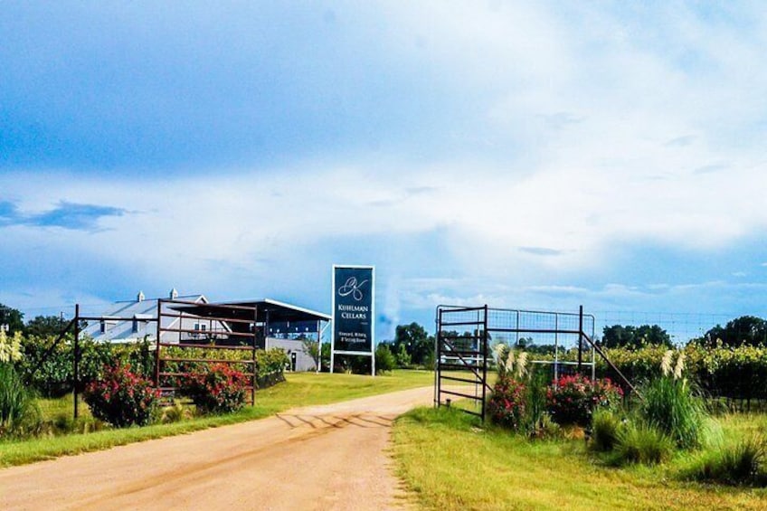 A rural road leading to a building with a sign reading 'KIRKLAND CELLARS.' 2