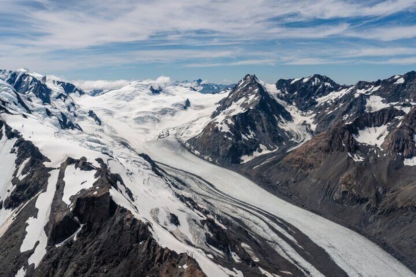 Een gletsjer in een bergachtig gebied met ruige toppen en besneeuwde hellingen. 3