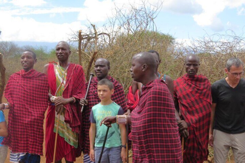 A group of people in traditional attire standing outdoors. 2